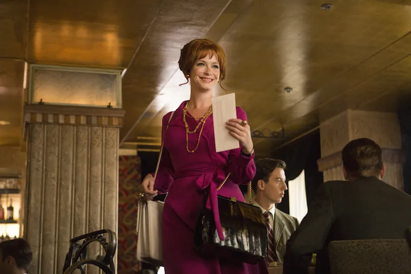 Lachende vrouw met een brief in haar hand loopt door een restaurant, still uit Mad Men
